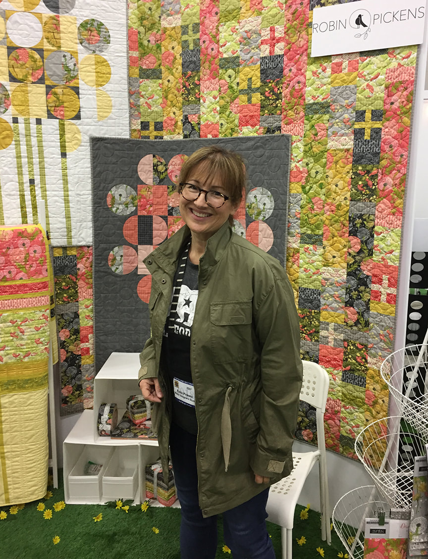 Robin Pickens at Portland Quilt Market after setting up booth at Moda with new Dandi Annie dandelion and birds line. 